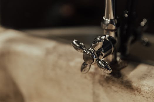 Close-up of a vintage metal faucet on a marble sink. Classic design with warm tones.