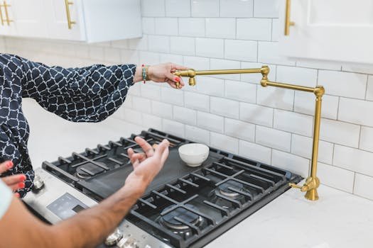 A stylish kitchen featuring a brass pot filler faucet and gas stove. Perfect for culinary enthusiasts and home design inspiration.